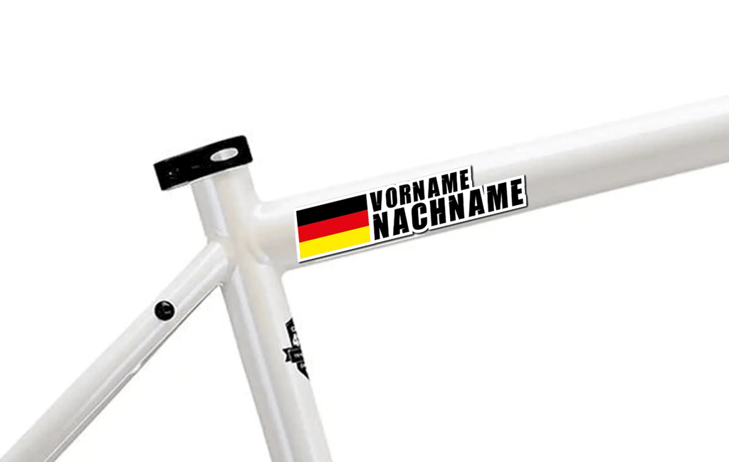 Pegatina personalizable con nombre y bandera alemana en marco de bicicleta blanco.
