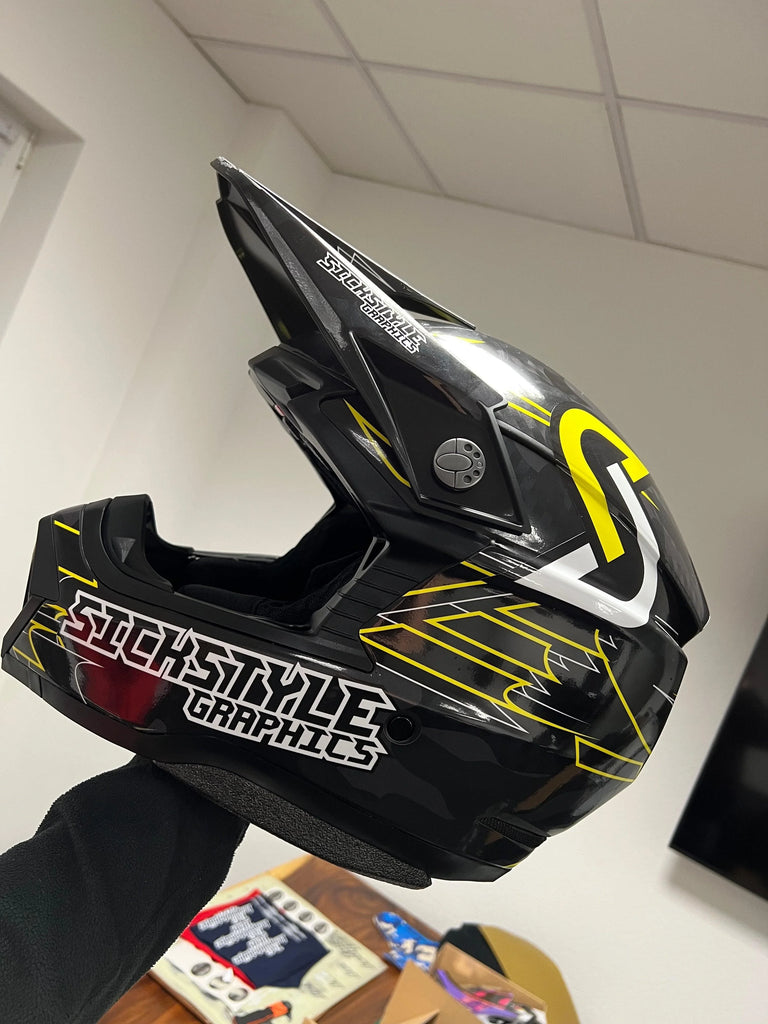 Svart motocross-hjälm med gula och vita 